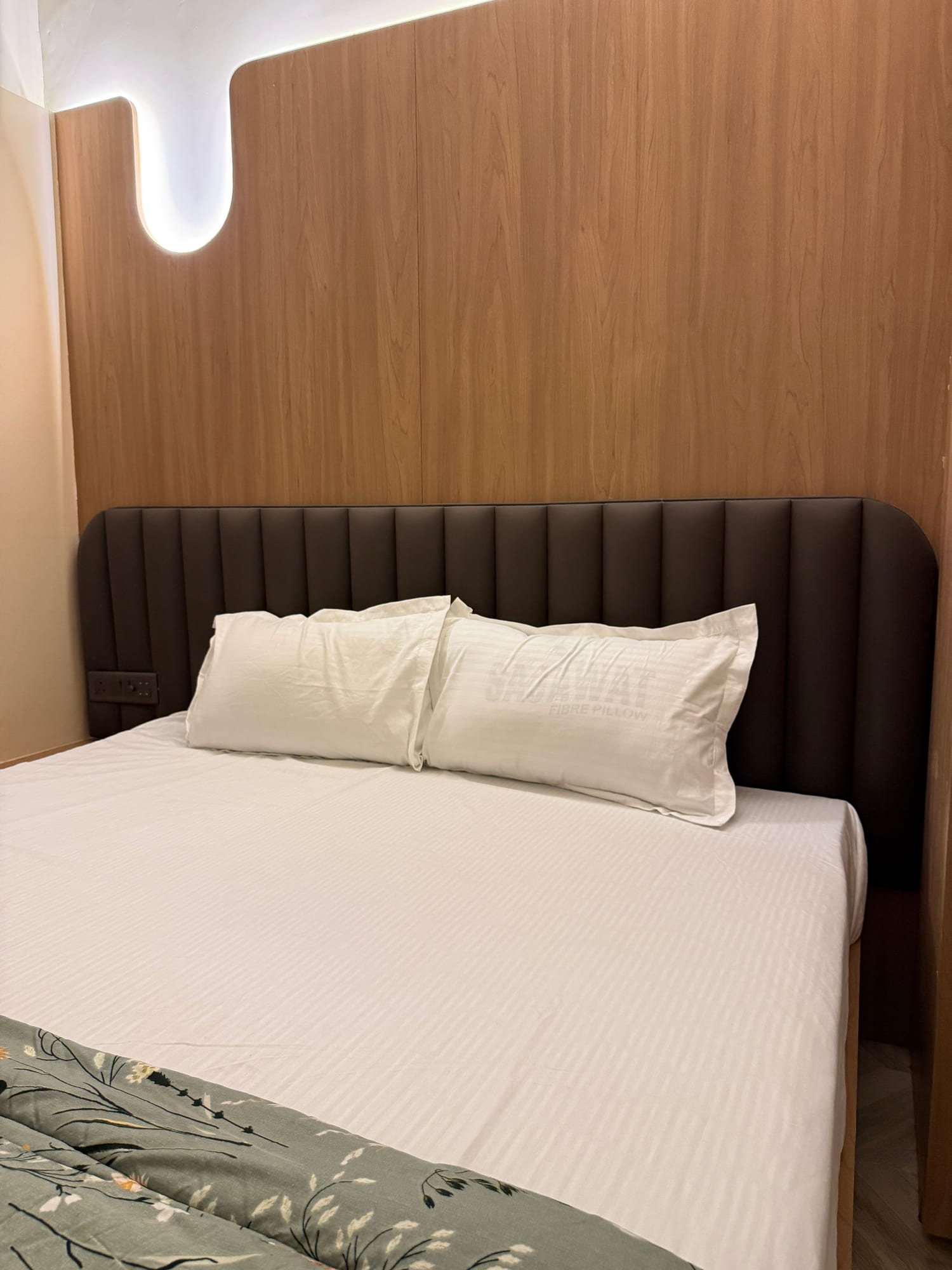 Crisp bed linens and wood headboard detail at The Cosmo